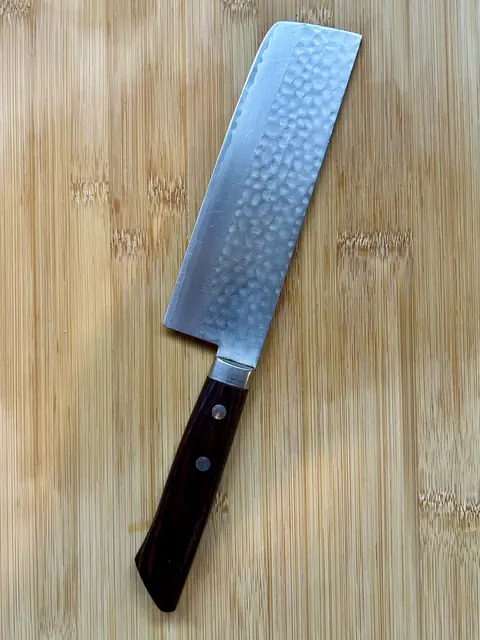 Japans hakmes met houten handvat op een houten snijplank