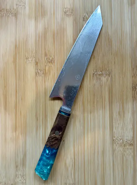 Japans koksmes met blauw houten handvat op een houten snijplank