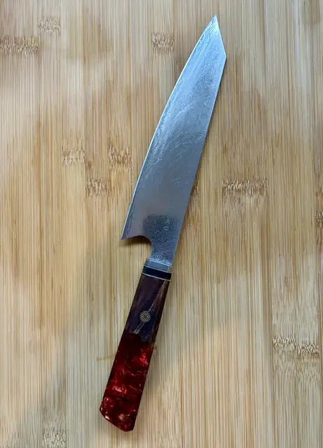 Japans koksmes met rood houten handvat op een houten snijplank